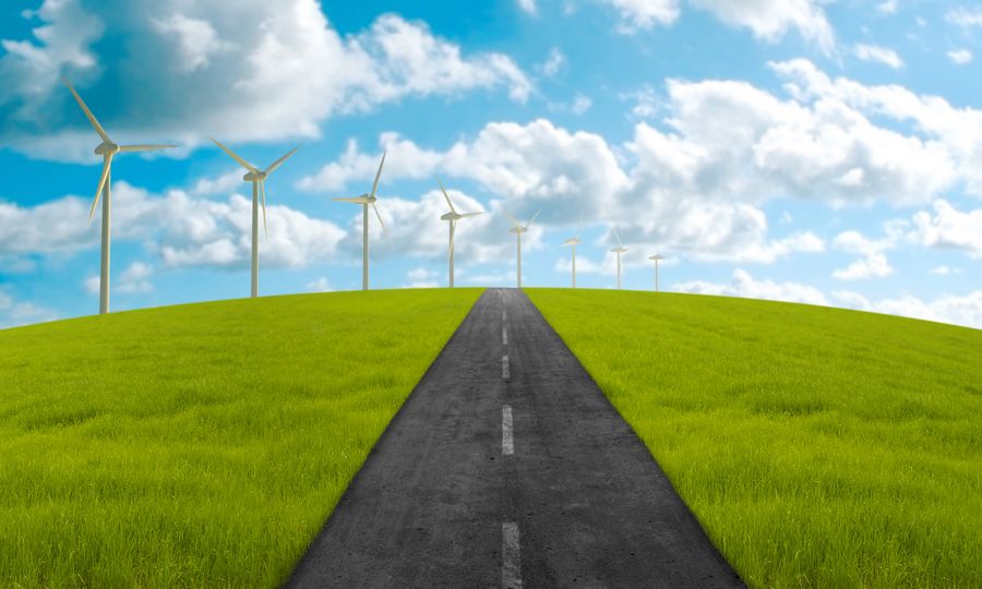 © Giordano Aita Dreamstime.com Road in green meadow towards the clean energy system